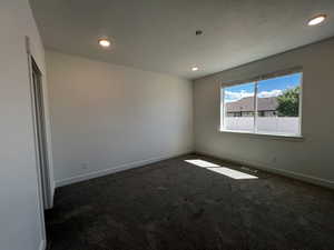 Empty room with dark colored carpet