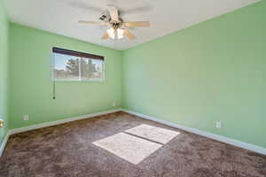 Carpeted empty room with ceiling fan