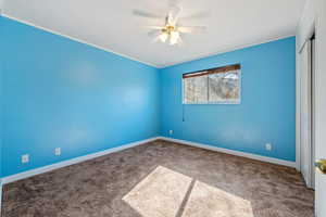 Carpeted spare room featuring ceiling fan