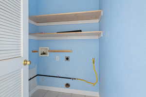 Laundry room with light tile patterned floors, hookup for a washing machine, and electric dryer hookup