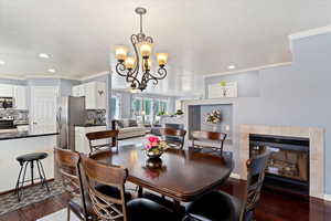 Dining space featuring an inviting chandelier, a textured ceiling, hardwood flooring, sider to backyard and crown molding.