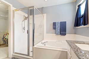 Bathroom featuring vanity, plus walk in shower, and a textured ceiling.