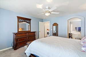 Carpeted bedroom featuring a textured ceiling and ceiling fan.