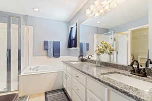 Bathroom with separate shower and tub, double sink vanity, and tile patterned flooring.