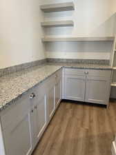 Kitchen featuring dark wood-type flooring and light stone countertops