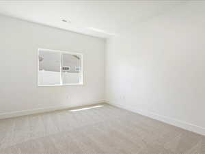 Empty room featuring light colored carpet