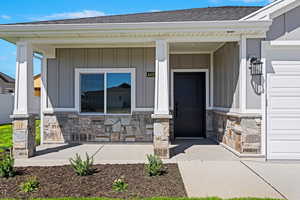 Doorway to property with a garage and covered porch