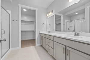 Bathroom featuring vanity, tile patterned floors, and a shower with door