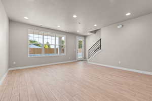 Spare room featuring a textured ceiling and light hardwood / wood-style flooring