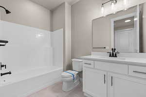 Full bathroom featuring toilet, bathtub / shower combination, vanity, and tile patterned flooring