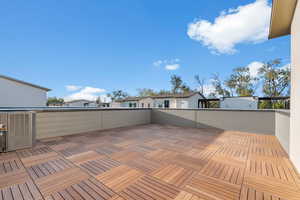 View of patio with cooling unit and a balcony