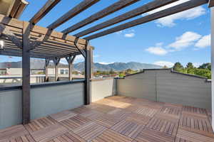 Wooden terrace featuring a mountain view and a pergola