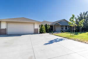 Ranch-style house featuring a garage and a front lawn