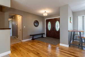 Foyer entrance featuring a textured ceiling and light hardwood / wood-style flooring