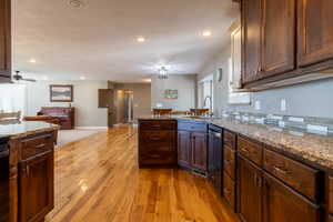 Kitchen featuring light hardwood / wood-style flooring, light stone counters, sink, and ceiling fan