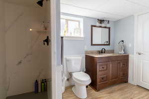 Bathroom featuring a drop ceiling, vanity, and toilet