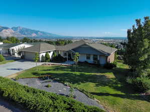 Ranch-style house featuring a mountain view, a garage, and a front yard