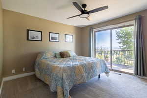 Carpeted bedroom with access to outside and ceiling fan