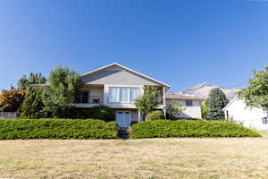 View of front facade with a mountain view and a front yard