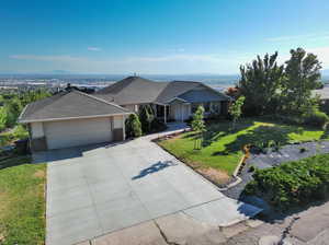 Single story home with a garage and a front lawn