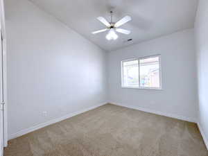 Spare room with light carpet, ceiling fan, and lofted ceiling