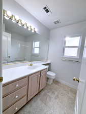 Bathroom featuring tile patterned floors, vanity, and toilet