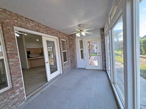 Unfurnished sunroom with a wealth of natural light and ceiling fan