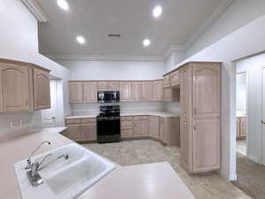 Kitchen featuring black range with electric cooktop, sink, light brown cabinets, and light tile patterned floors