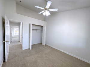 Unfurnished bedroom with light carpet, a closet, and ceiling fan