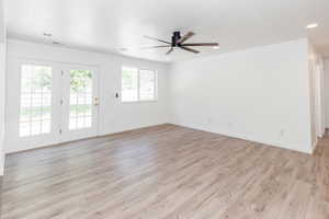 Empty room featuring light hardwood / wood-style flooring, a healthy amount of sunlight, and ceiling fan