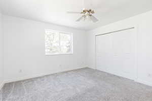 Unfurnished bedroom with light carpet, ceiling fan, and a closet