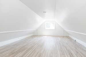 Bonus room with lofted ceiling and light hardwood / wood-style floors