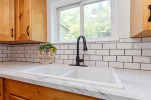 Room details featuring sink and light stone countertops