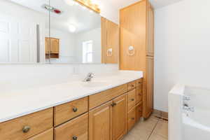 Bathroom featuring tile patterned floors, vanity, and a bathtub