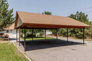 View of vehicle parking with a carport and a lawn