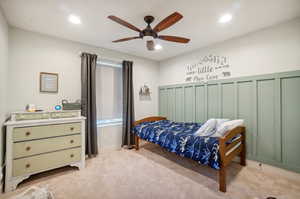 Carpeted bedroom with two closets and ceiling fan