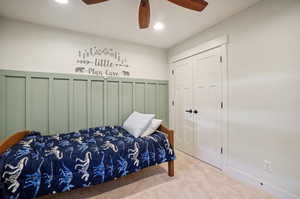 Bedroom with multiple closets, light colored carpet, and ceiling fan