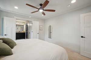 Bedroom featuring ensuite bathroom, light colored carpet, and ceiling fan