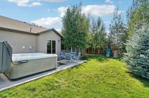 View of yard featuring a playground, a patio, and a hot tub