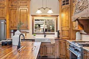 Kitchen with sink, backsplash, stainless steel stove, and butcher block counters