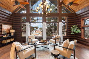 Interior space with wood ceiling, log walls, high vaulted ceiling, and wood-type flooring