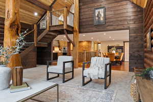 Living room featuring beamed ceiling, wooden ceiling, high vaulted ceiling, and wood walls