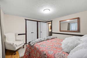 Bedroom with a textured ceiling and hardwood / wood-style flooring