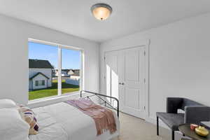 Bedroom featuring light carpet