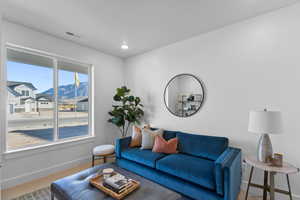 Living room featuring carpet, a mountain view, and a healthy amount of sunlight