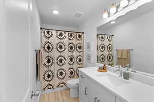 Bathroom with vanity, toilet, and hardwood / wood-style floors