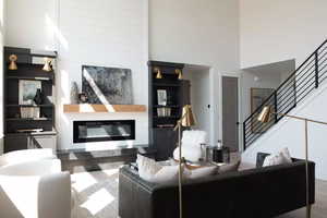 Living room featuring a fireplace and a towering ceiling