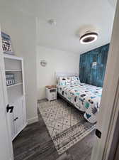 Bedroom with light hardwood / wood-style floors and a textured ceiling