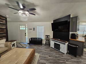 Living room featuring hardwood / wood-style flooring, a textured ceiling, and ceiling fan