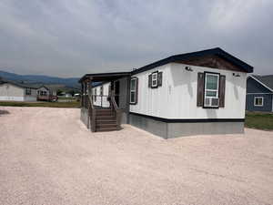 View of front of home with a mountain view and cooling unit